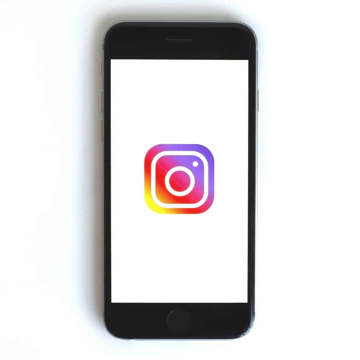 Phone showing Instagram logo on screen.