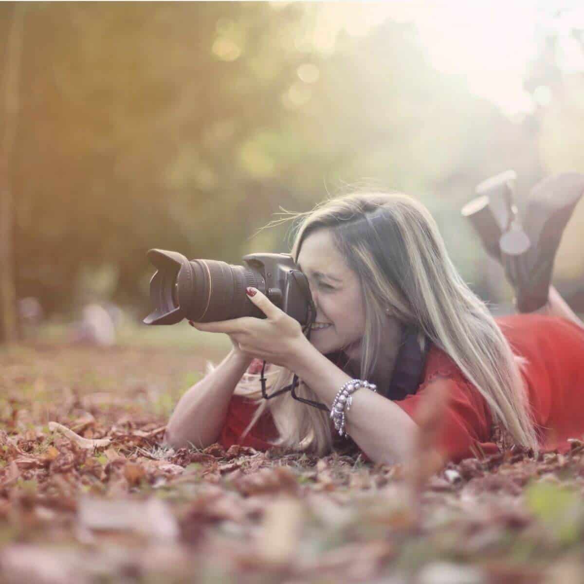 Photographer lying on the ground while taking a photo.