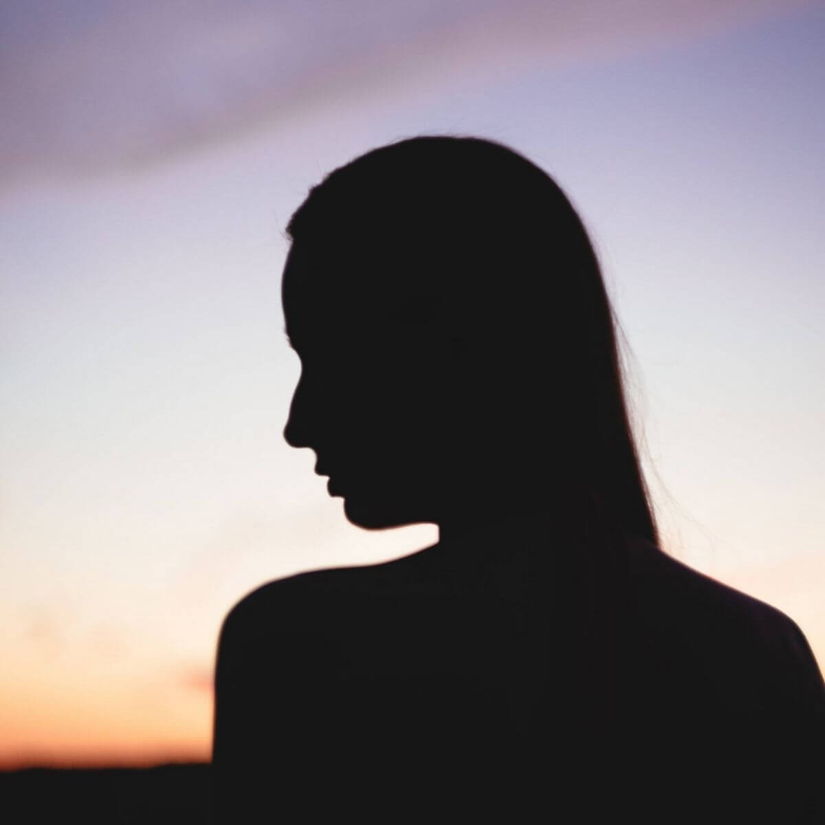 Silhouette of a person looking to the left during a sunset.