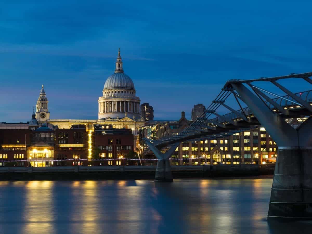 Buildings, bridge, and river during blue hour in London.