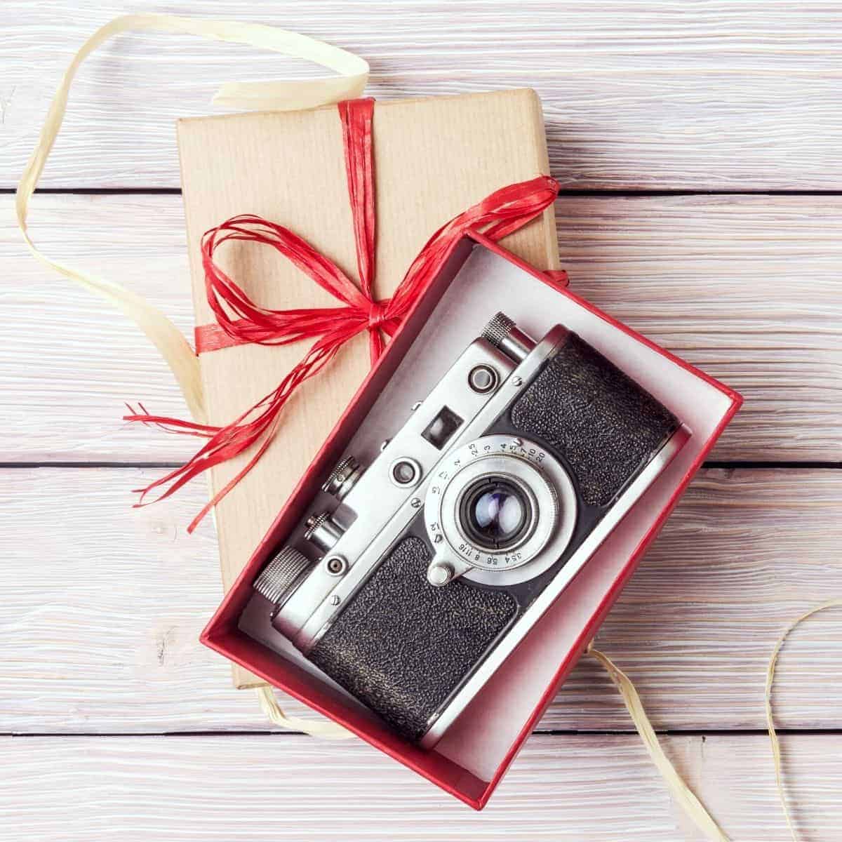 Camera in a gift box on a wooden table.