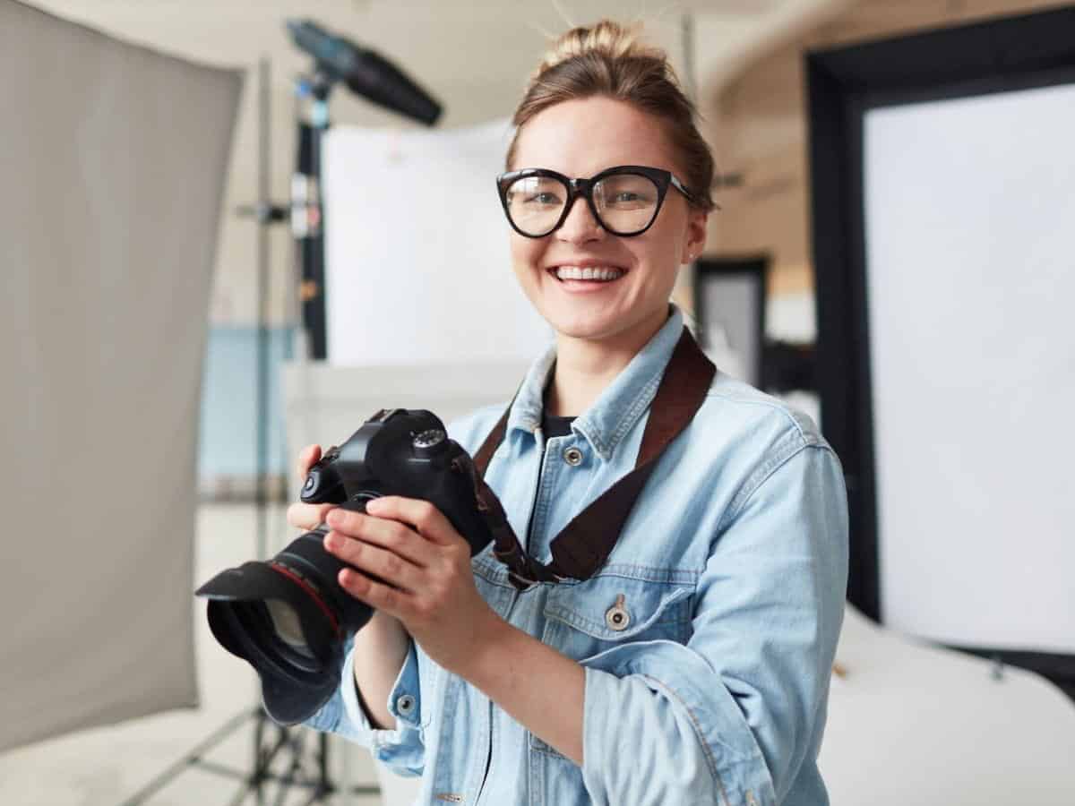 Photographer holding a camera in a studio.