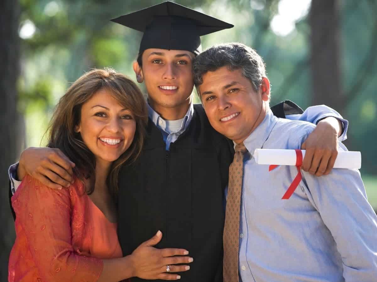 Graduate with his parents outdoors.