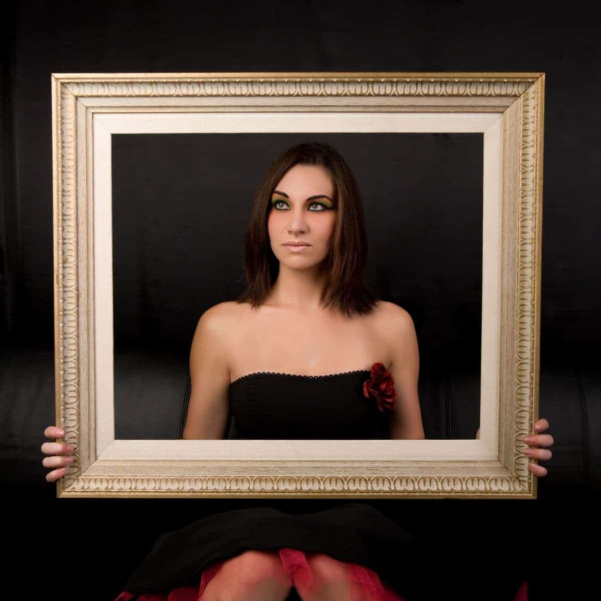Portrait of a woman holding a frame.