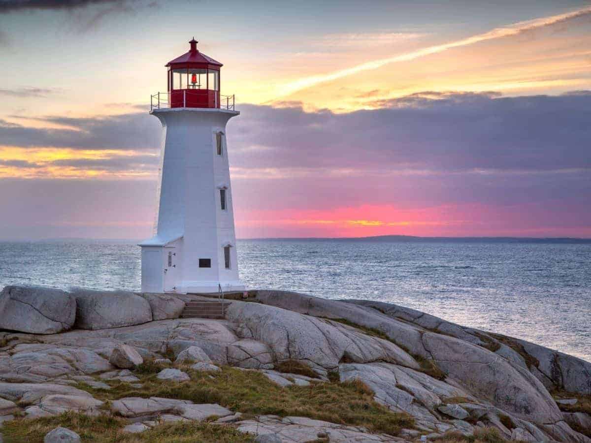 Lighthouse near water and a sunset.