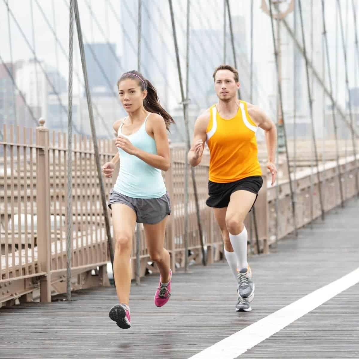 Man and woman running on a bridge.