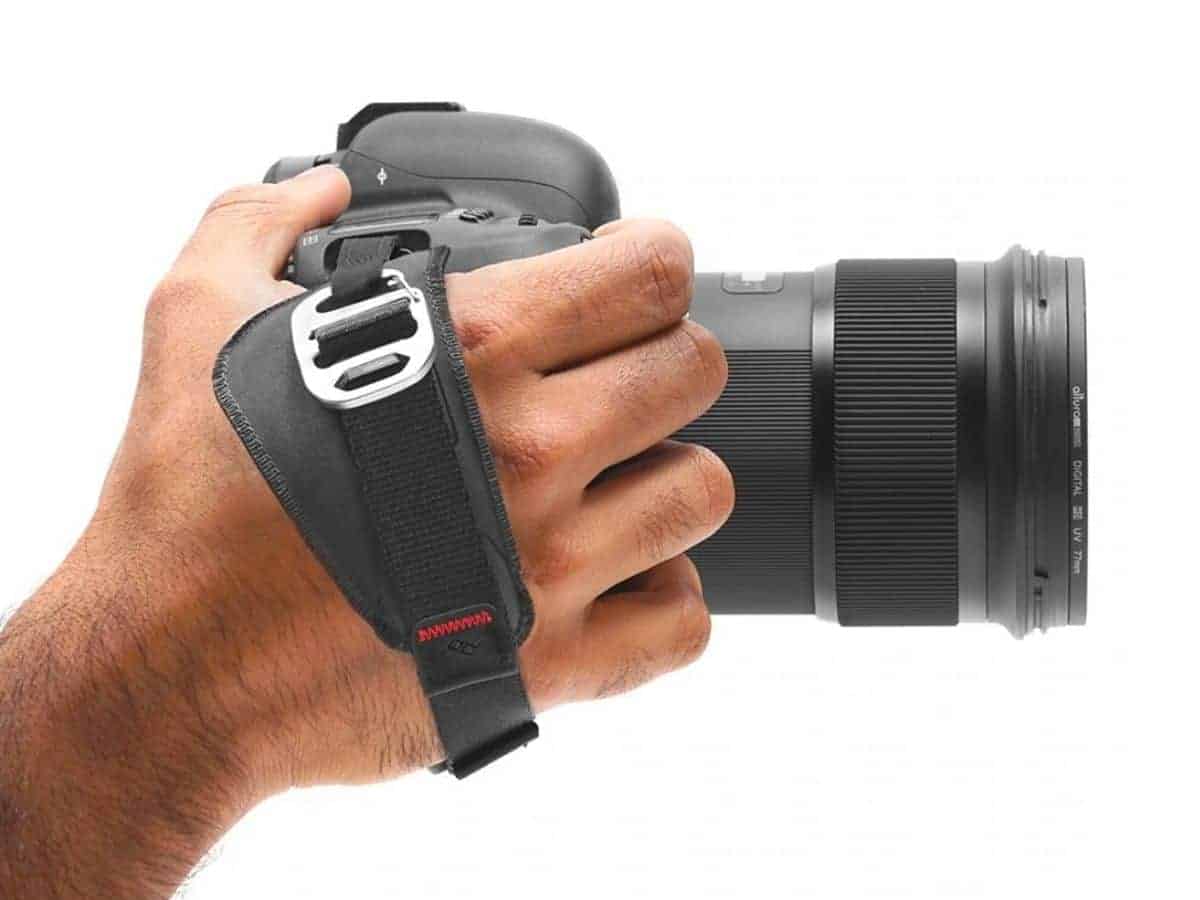 Person using a Peak Design camera hand strap.