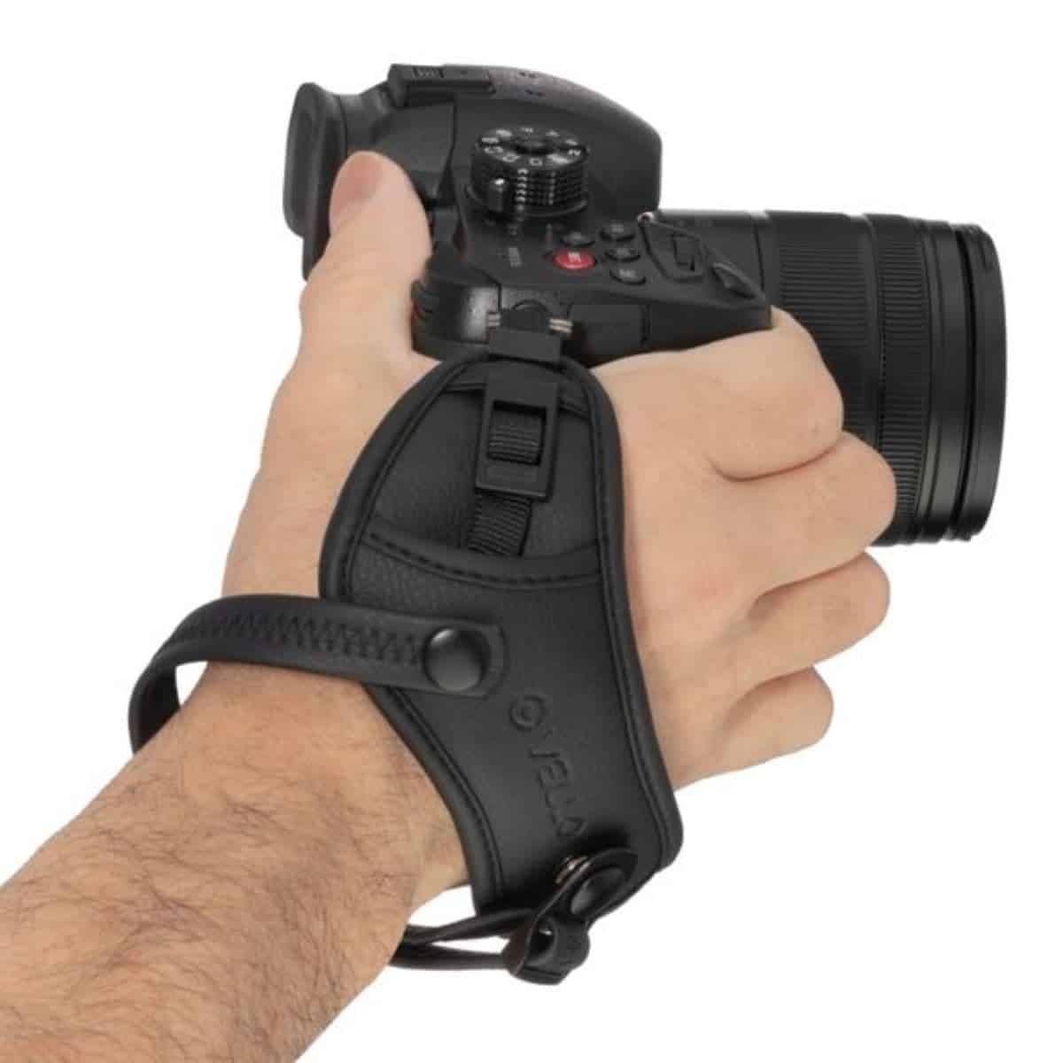 Hand with a Vello camera hand strap.