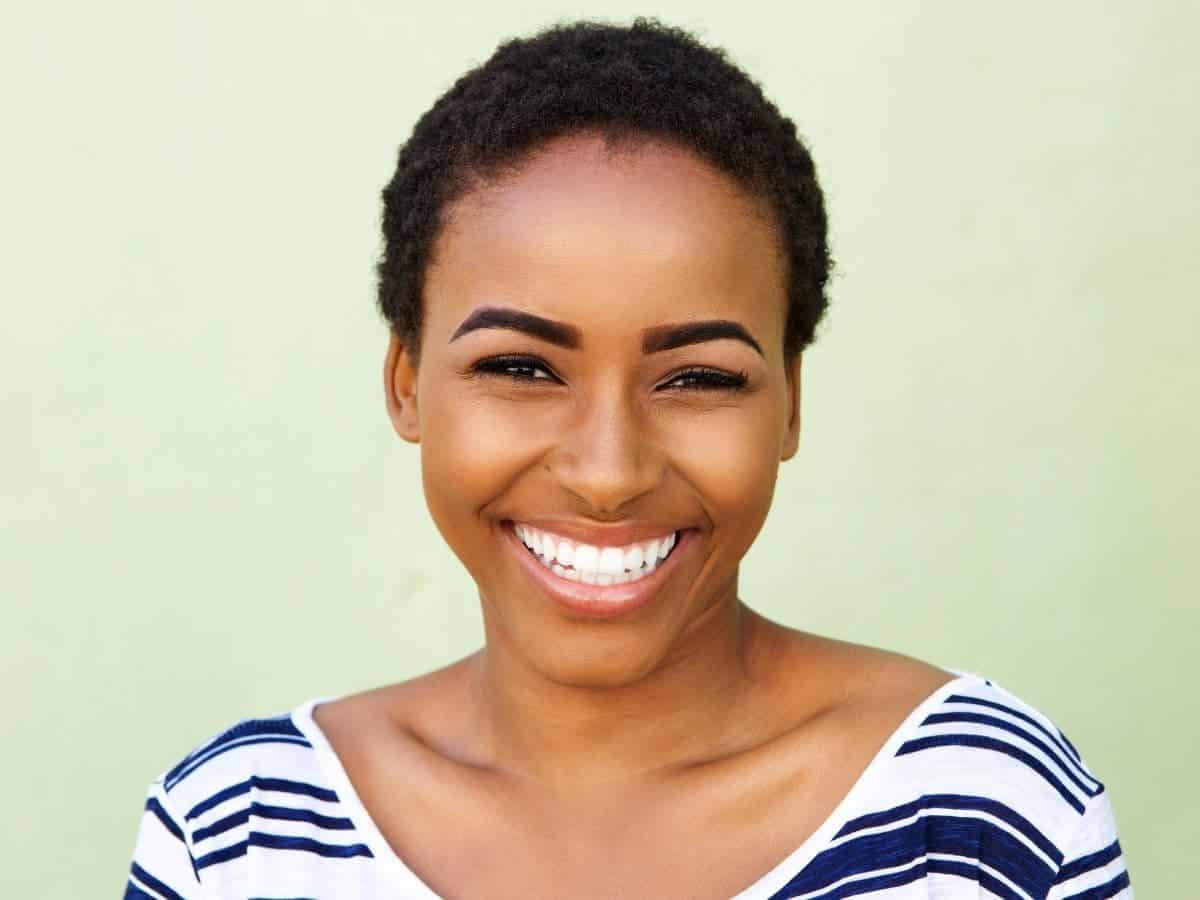 Person with a short afro smiling.