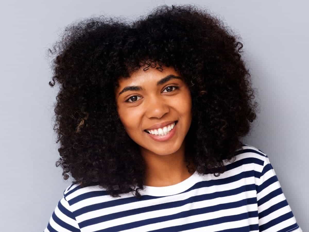Person with afro hair smiling.