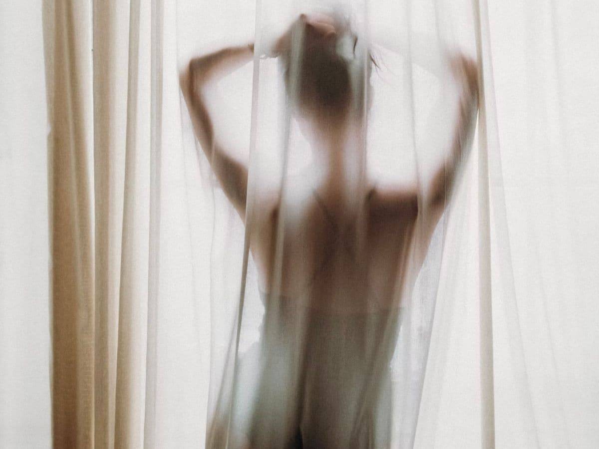 Woman behind a curtain.