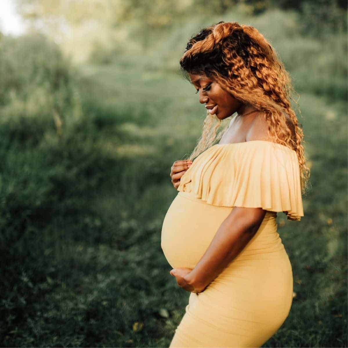 woman pregant outdoors yellow dress