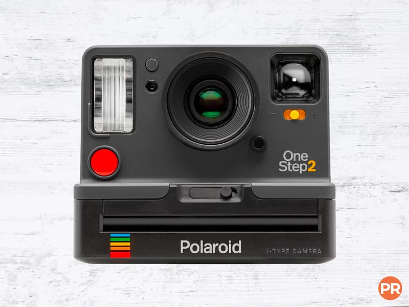 Polaroid OneStep 2 instant camera with a wood background.