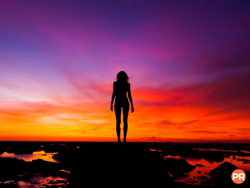 Silhouette portrait of a woman on a beach during sunset.
