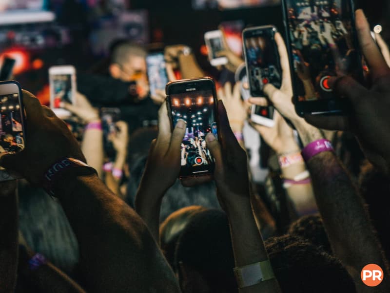 People holding up phones and recording a concert.